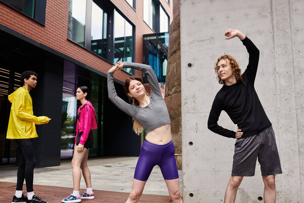 Молодые спортсмены занимаются упражнениями на растяжку в оживленной городской атмосфере под ясным небом.