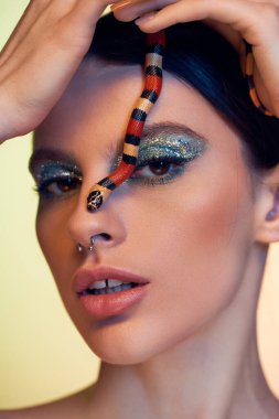 Zarif genç bir kadın zarafetini sergiliyor canlı bir yılanın yüzlerinin üzerinde süzülmesi gibi..