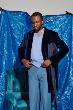 Yakışıklı genç adam elbisesini ayarlıyor, dikkat çekici bir mavi ayar sergiliyor..