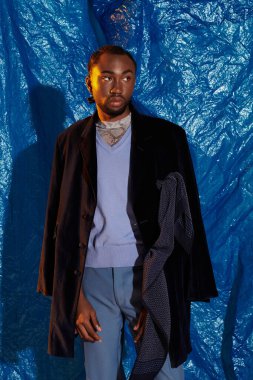 Şık bir genç adam kendine güveni tam bir şekilde duruyor..