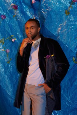 Yakışıklı bir genç adam kendine güvenerek şık bir kıyafet giyer, çekiciliğini ve tarzını sergiler..