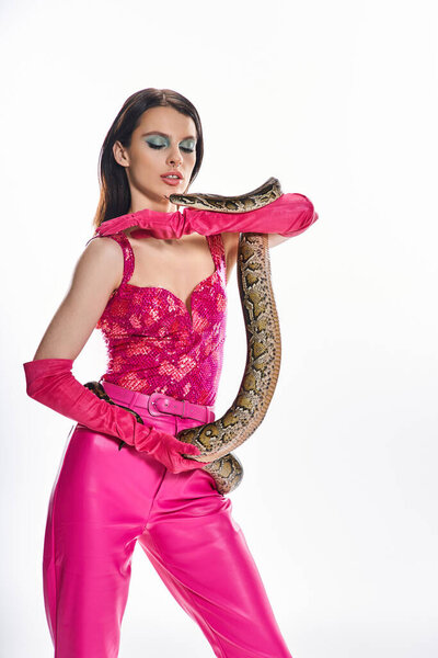 Уверенная в себе молодая женщина элегантно позирует со змеей на руке.