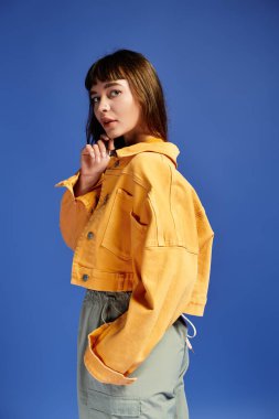 Şık genç bir kadın, şık sarı ceketi ve canlı renkleriyle modasını sergiliyor..