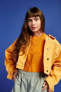 Kendine güvenen genç bir kadın modaya uygun bir şekilde poz veriyor, eşsiz stilini ve kentsel yeteneğini vurguluyor..