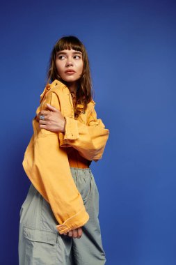 Modayı takip eden genç bir kadın modaya uygun bir şekilde poz veriyor ve tarzının altını çiziyor..