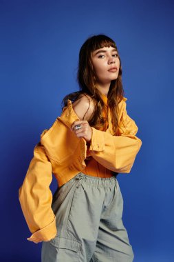 Genç bir kadın şık kıyafetler, ışıl ışıl bir tarz ve güzellikle kendine güvenerek poz verir..