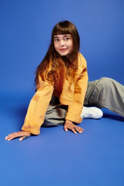 Genç bir kadın yerde otururken eşsiz moda anlayışını sergiliyor..