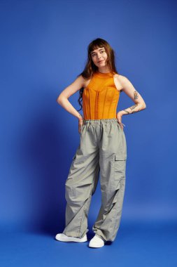 Modayı takip eden genç bir kadın modaya uygun giyinmiş, cazibeli ve tarz sahibi..