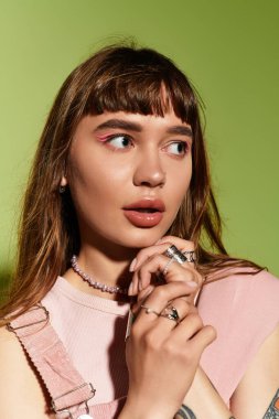 Çarpıcı özellikleri ve şık kıyafetleri olan genç bir kadın kendine güvenen bakışlarıyla dikkatleri üzerine çekiyor..