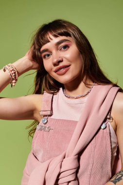 Genç bir kadın şık kıyafetlerini özgüvenle sergiliyor, zarif bir şekilde aksesuar takıyor..