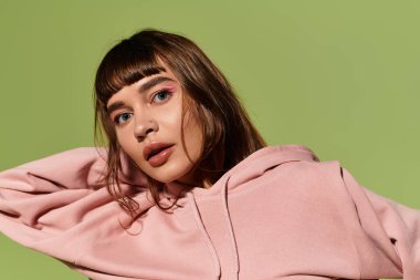 Şık bir kadın kendine has çekiciliğini renkli bir makyajla ve rahat bir pozla sergiler..