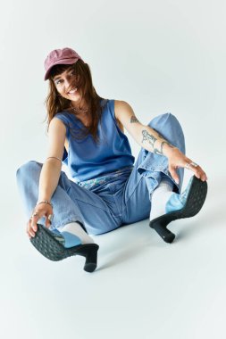 Moda kıyafetleri içindeki genç bir kadın, kendine güvenini ve tarzını sergileyerek neşe içinde poz veriyor..