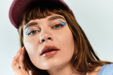 Şık bir genç kadın kendine güvenerek poz verir. Kalın makyaj, şık kıyafetler, göz alıcı bir cazibe..