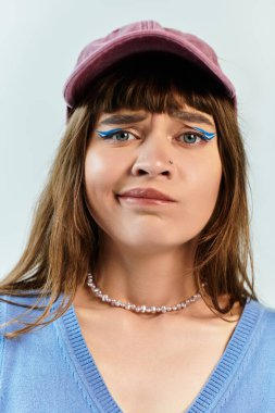 Modern bir mekanda, genç bir kadın modaya uygun kıyafetini ve çarpıcı makyajını gururla sunar..