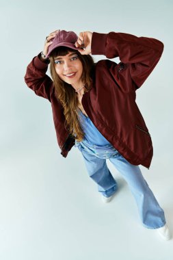 Moda kıyafetleri içinde genç bir kadın, eşsiz tarzını canlı bir şekilde ifade ederek neşeli poz veriyor..