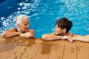 İki aktif ve güzel olgun kadın, spa havuzunda huzurlu bir anın tadını çıkarıyorlar..