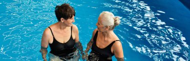İki güzel olgun kadın, bir sağlık merkezinin havuzunda huzur dolu bir deneyimin keyfini çıkarıyorlar.