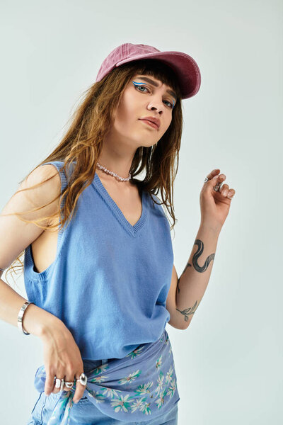 Молодая женщина уверенно позирует в модном наряде, подчеркивая свой уникальный стиль и элегантность.