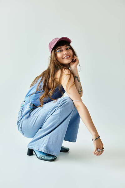 Молодая женщина с длинными волосами и шляпой демонстрирует свой модный наряд, позируя игриво.