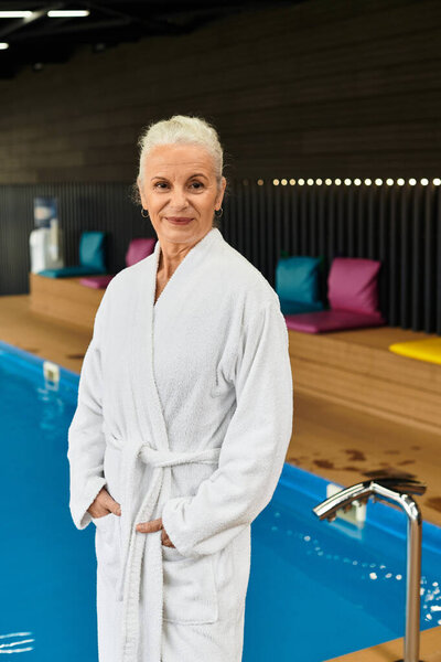 A mature woman enjoys tranquility and relaxation at the wellness center poolside.