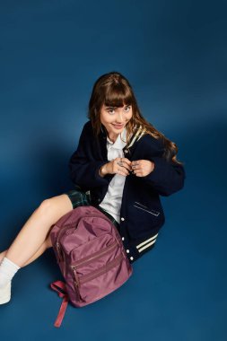 Sırt çantalı genç bir kadın çalışmalarına hazırlanmaktan zevk alıyor. Mutluluk ve güven saçıyor..