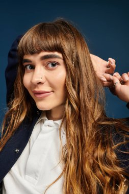 Uzun saçlı mutlu bir genç kadın gülümsüyor, akademik yolculuğuna başlamak için heyecanlı..