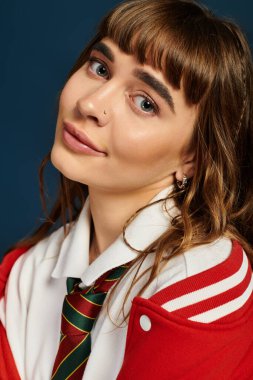 Güzel hatları olan mutlu bir kız öğrenci moda bir üniforma giyerken çalışmalarının keyfini çıkarıyor.