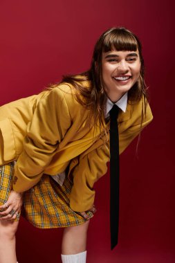 Şık giyinmiş gülümseyen bayan öğrenci dersleri sırasında eğleniyor ve eğleniyor..