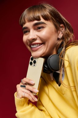 Sıcak bir atmosferde kulaklık takıp muhabbet eden neşeli kız öğrenci.