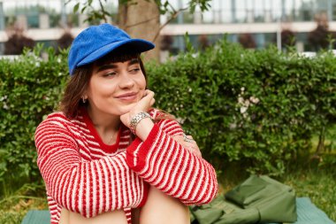 Genç kız öğrenci, çalışmalarına dalmışken güneşli bir açık havada mutlu bir şekilde yansıyor..