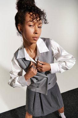 Genç bir kadın şık bir iş elbisesiyle şık bir şekilde evde dikiliyor..