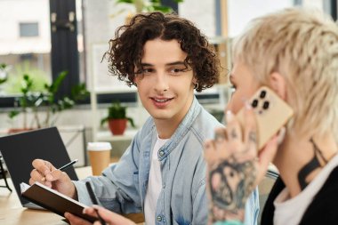 İki genç profesyonel modern ofis ortamında birlikte çalışıyor, fikirleri paylaşıyor ve odaklanıyorlar..