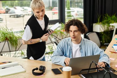 İki genç profesyonel, ortak bir çalışma oturumunda fikirleri ve araçları paylaşıyorlar..