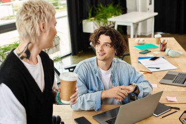 Çağdaş bir ofiste birbiriyle etkileşen iki genç, fikirleri paylaşıyor ve iş günlerinden zevk alıyorlar..