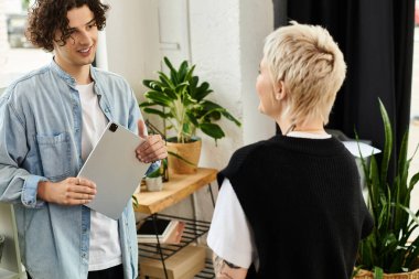 İki genç profesyonel, canlı bir ofis ortamında, fikirleri ve ilhamı paylaşıyor..