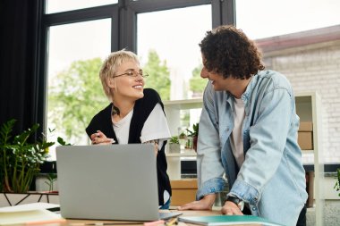 İki meşgul genç çalışan, canlı bir ofis ortamında beyin fırtınası yapıyorlar..