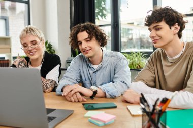 Modern bir çalışma alanında özenle işbirliği yapan üç genç profesyonel, fikirleri ve sezgileri paylaşıyor..