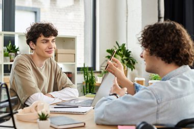 İki genç profesyonel şık bir ofiste aktif olarak iletişim kuruyor, fikirleri ve sezgileri paylaşıyorlar.