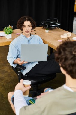 Geniş bir ofiste çalışırken iki genç profesyonel dinamik bir tartışmaya giriştiler..