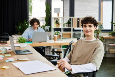 İki genç, parlak ve modern bir ofiste takım çalışması ve üretkenlik göstererek iş birliği yapıyor..