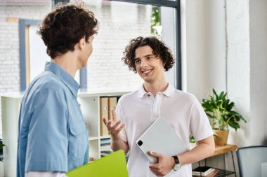 İki genç insan coşkulu bir ofiste hevesle sohbet ediyor, fikirleri paylaşıyorlar..