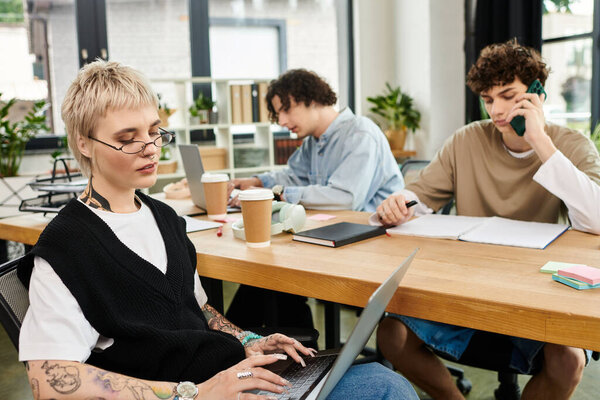 Молодые специалисты сосредоточены на различных задачах в современной офисной среде, способствуя совместной работе.