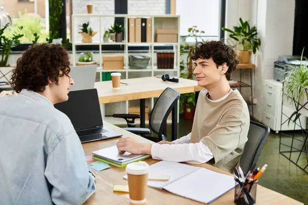 İki genç, parlak bir ofiste hevesle fikir ve projelerini paylaşıyor..