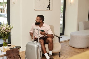 Gezgin adam şık bir otel lobisinde vakit geçiriyor. İleride tatil maceralarına hazır..