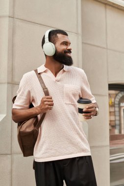 Afro-Amerikan bir adam kahve molası verirken şehir manzarasını keşfediyor..