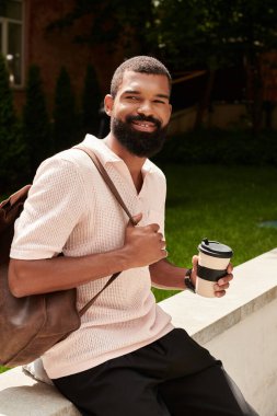 Zarif bir Afro-Amerikan erkeği canlı bir şehri keşfederken açık havada kahve içmekten zevk alır..