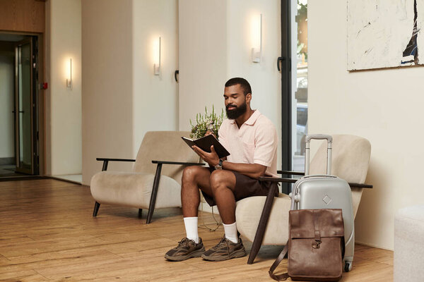 Стильный человек расслабляется в вестибюле отеля, готовясь к предстоящему путешествию.