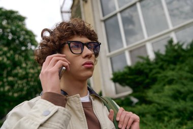 Yakışıklı bir genç adam dışarıda gezintiye çıkıyor, doğanın ortasında telefonla konuşuyor..