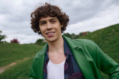 Yakışıklı öğrenci yemyeşil bir parkta geziniyor, temiz havayı ve doğayı kucaklıyor..