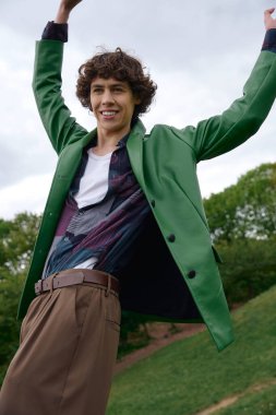 Neşeli genç bir adam güzel doğadaki temiz havayı kucaklayarak, sakin bir yürüyüş yapar..